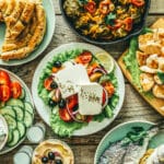 Selection of traditional greek food - salad, meze, pie, fish, tzatziki, dolma on wood background, top view