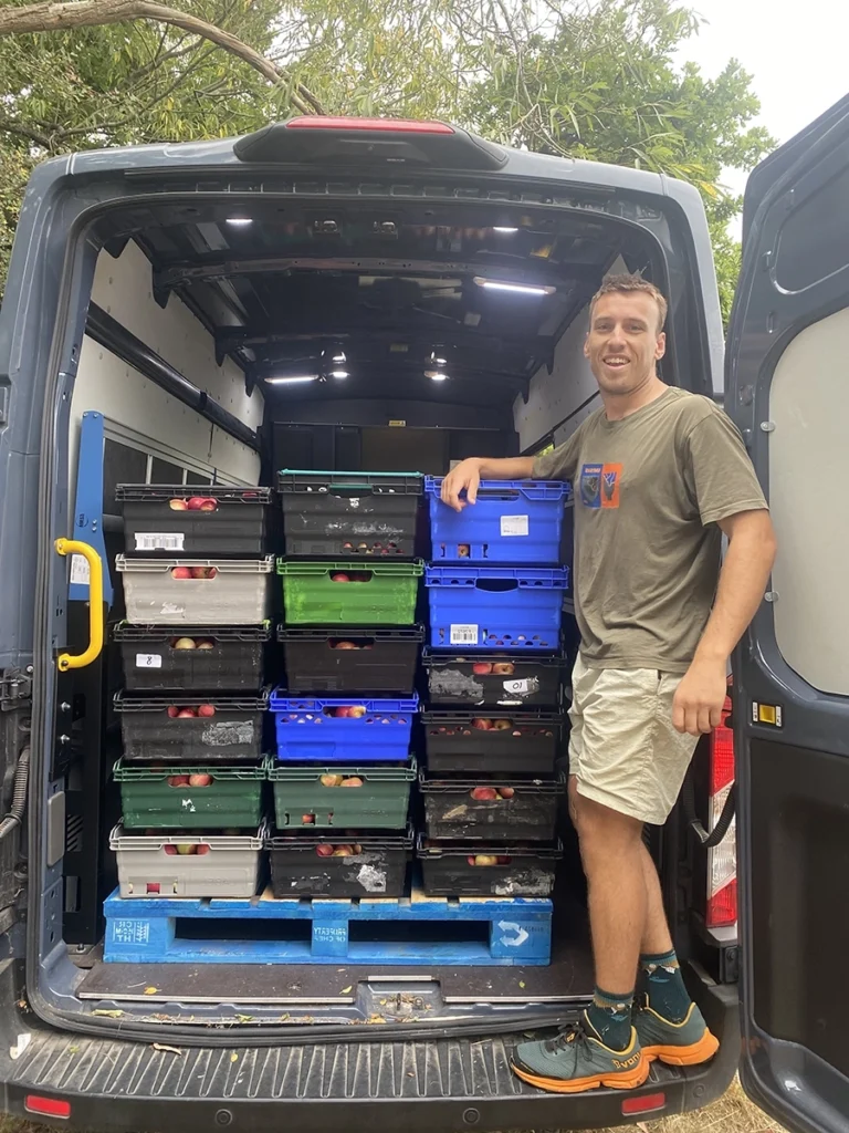 Fin Kenneth standing in a van full of apples